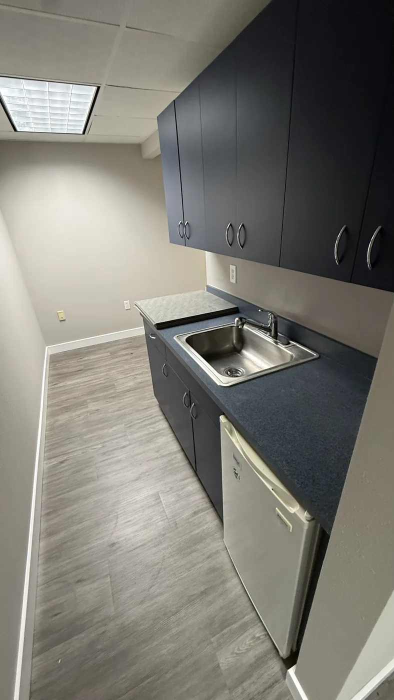 Shared kitchenette with sink and refrigerator.